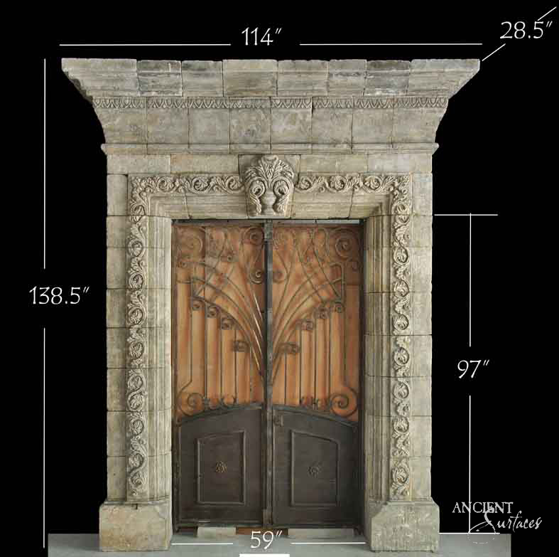 Monumental limestone portal with foliate-carved jambs and an acanthus crest over iron-and-wood doors
