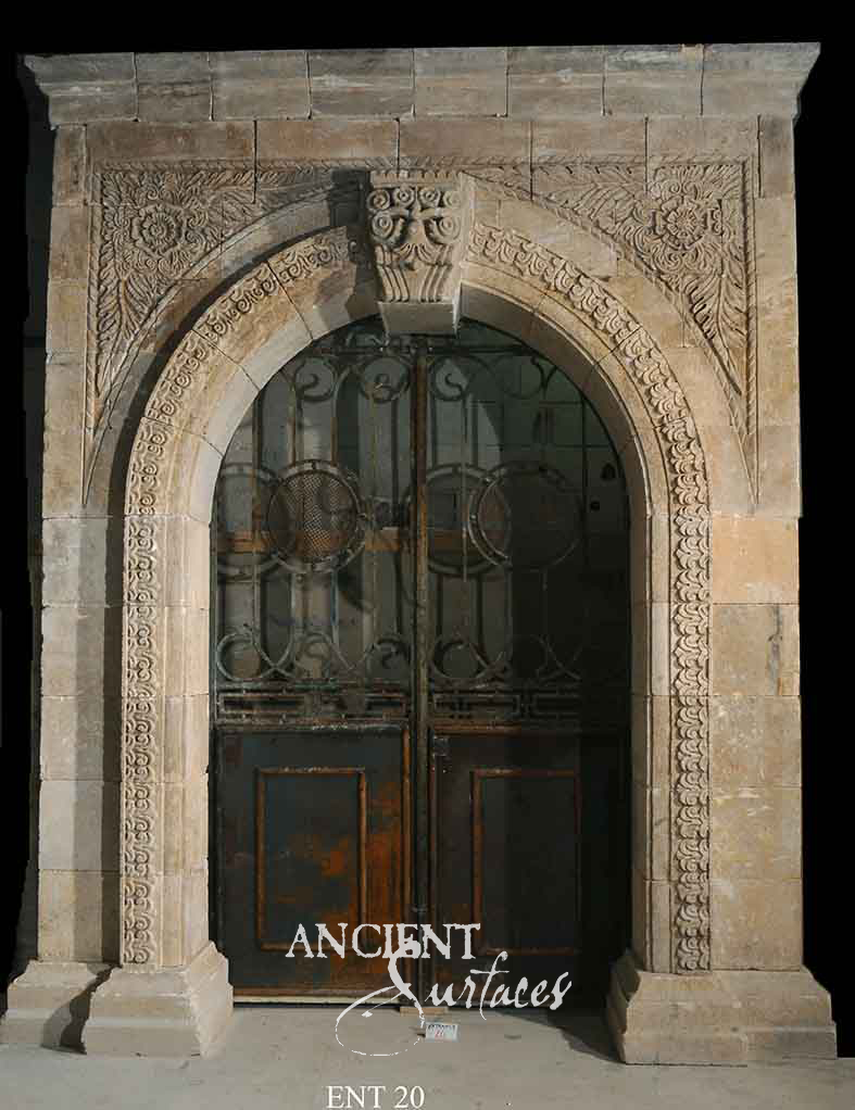 Moorish-carved limestone door surround with a round arch and iron-grilled timber doors